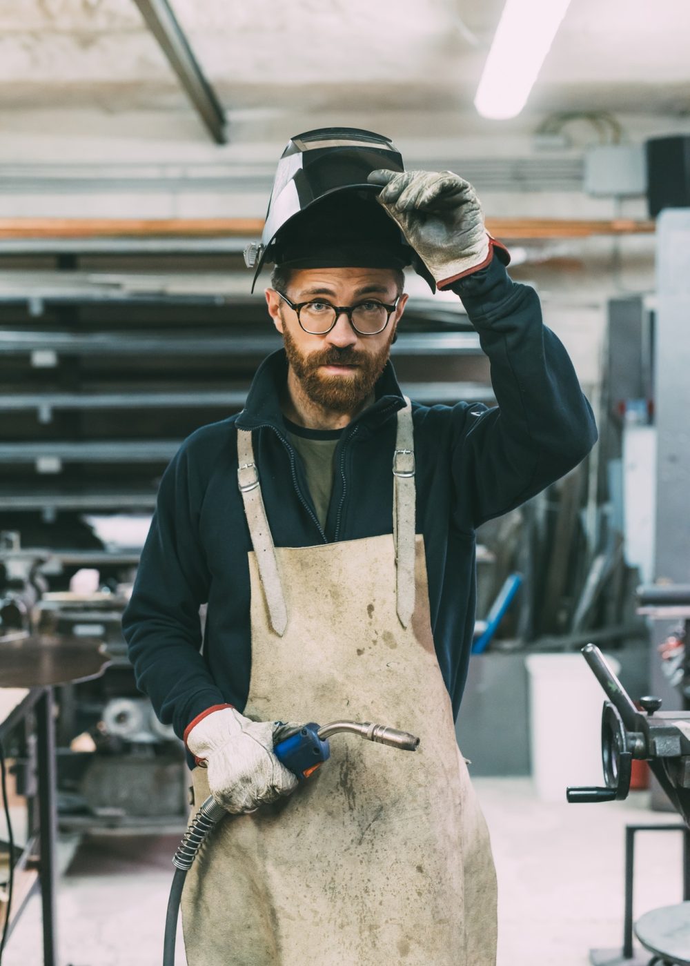 portrait-of-metalworker-holding-welding-torch-in-forge-workshop.jpg